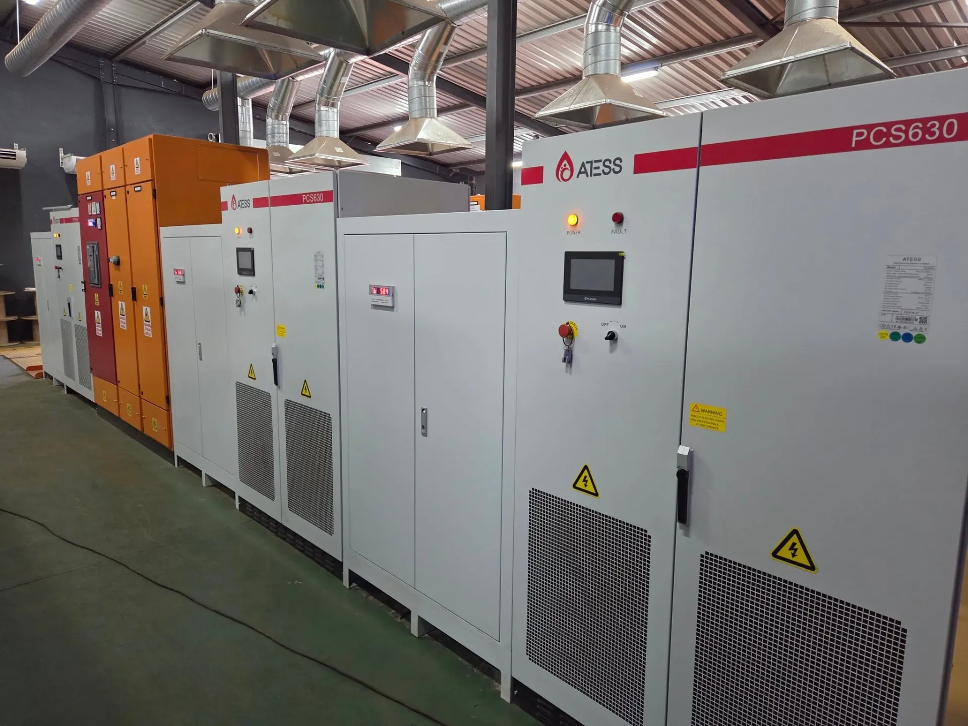 ATESS PCS630 power conversion cabinets and orange switchgear lined up along a plant room wall